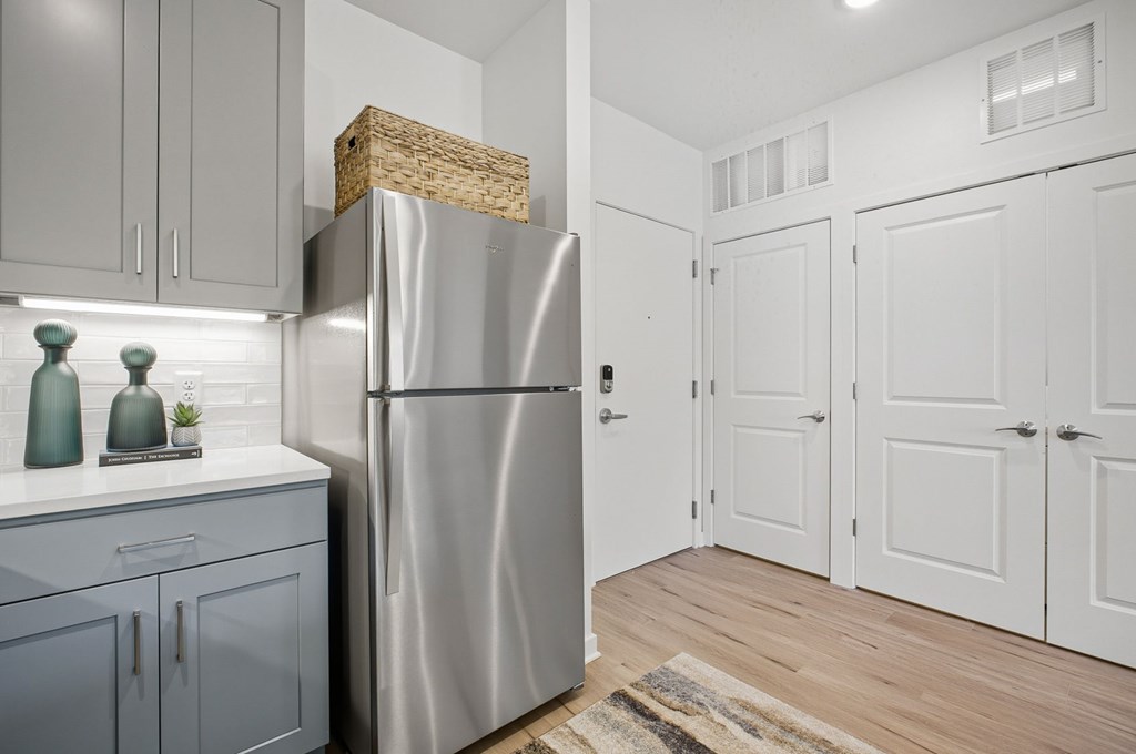 A modern kitchen with a stainless steel refrigerator and wooden countertop.