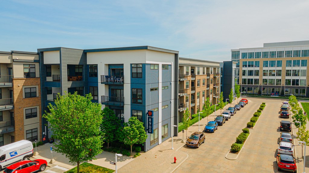 an aerial view of an apartment complex with cars parked in a parking lot