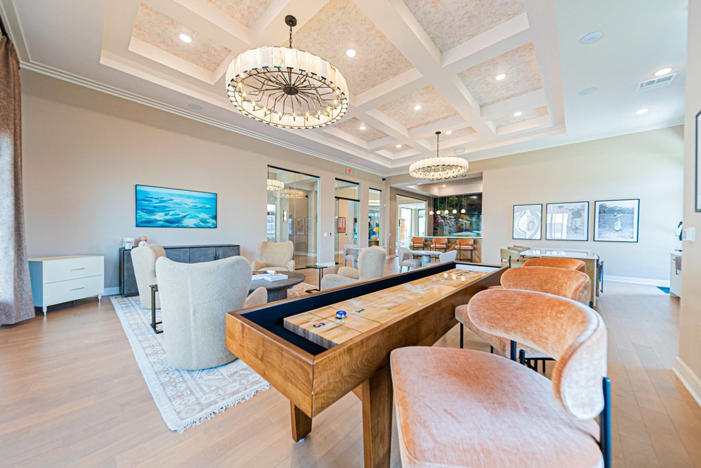 A large wooden dining table with chairs around it in a well-lit room.