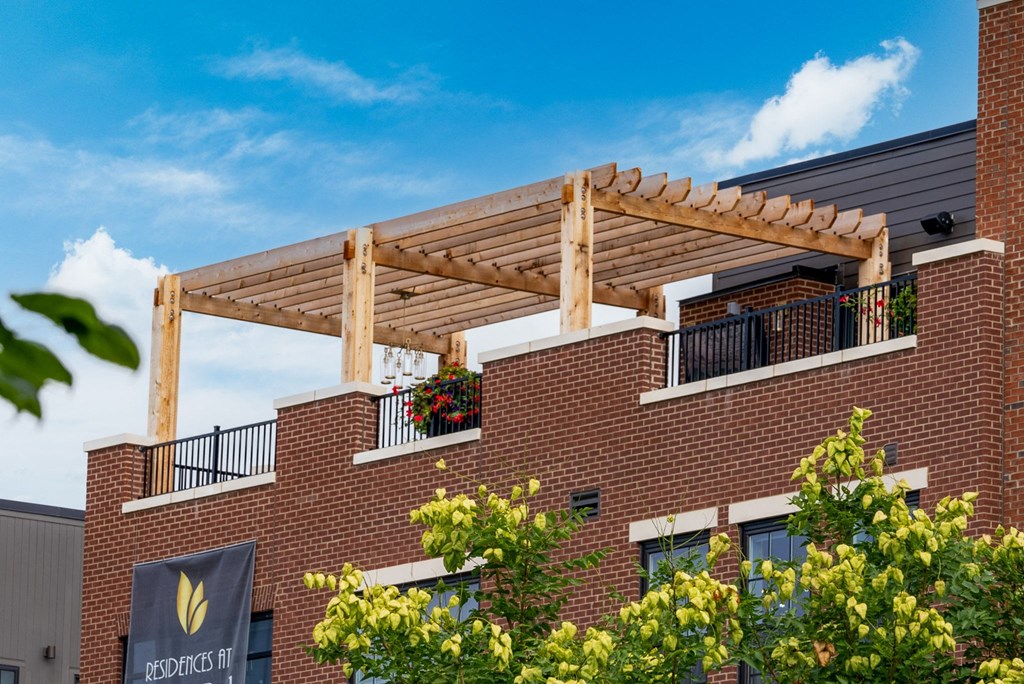 a wooden pergola on top of a brick building