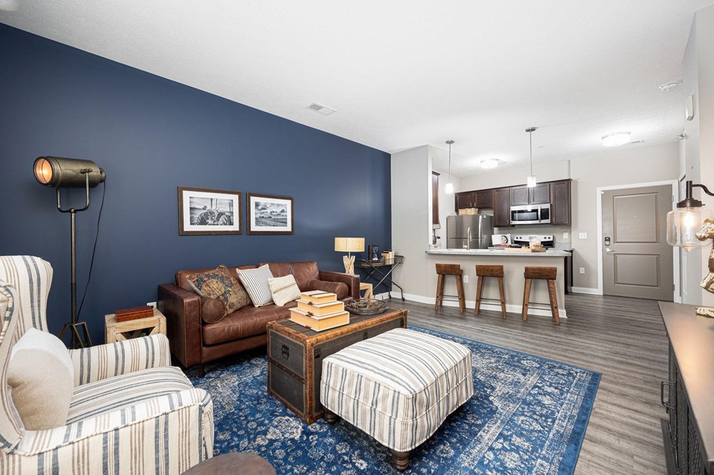 a living room with a couch and a chair in front of a kitchen