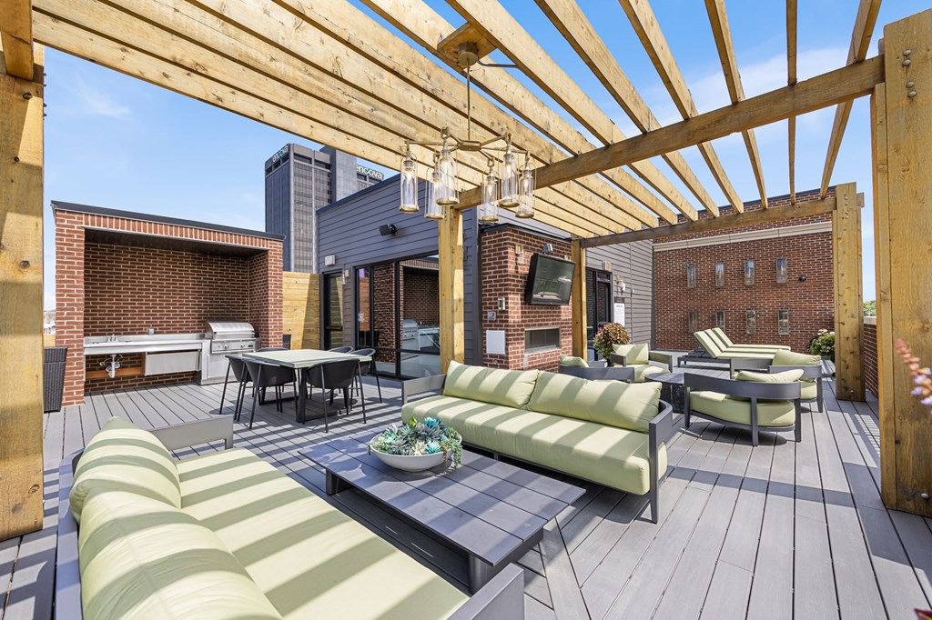A wooden deck with a striped couch and a table.