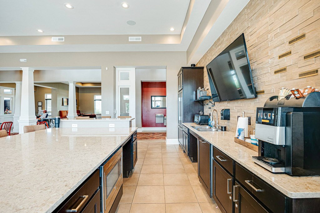 a large kitchen with a coffee machine and a television