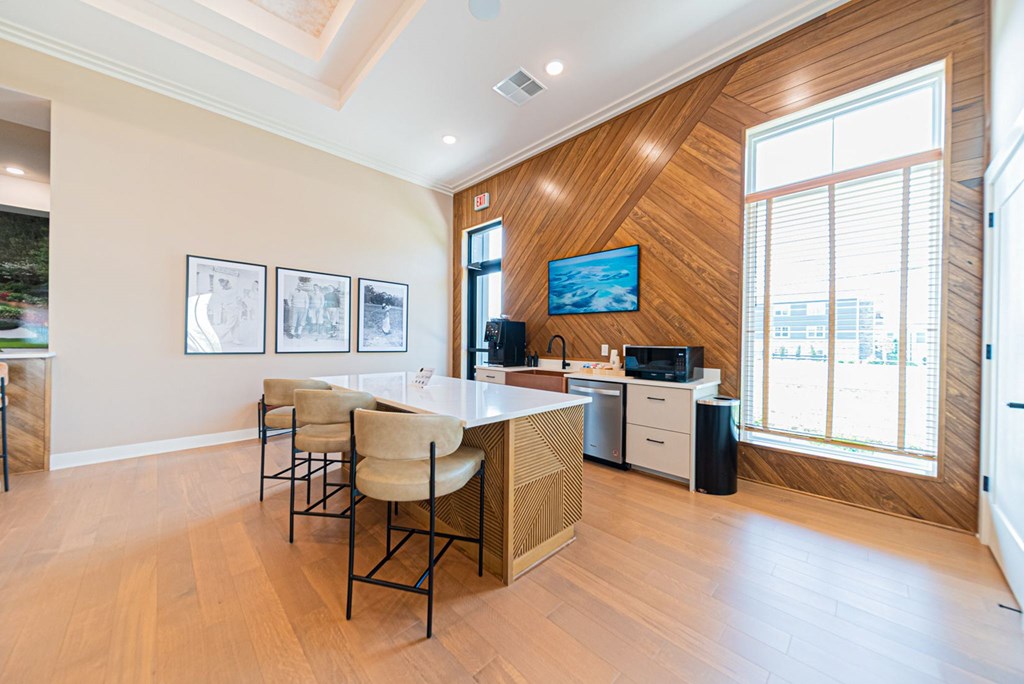 A modern kitchen with a wooden wall and a TV mounted above the island.