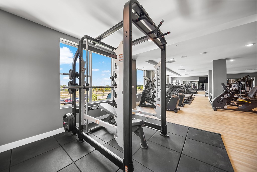 A gym with a weight bench and a window showing the outside.