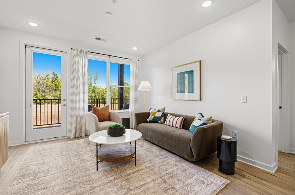 A living room with a couch, coffee table, and sliding glass doors.