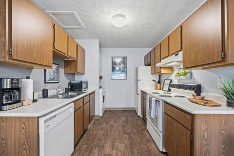 A kitchen with white appliances and wooden cabinets.