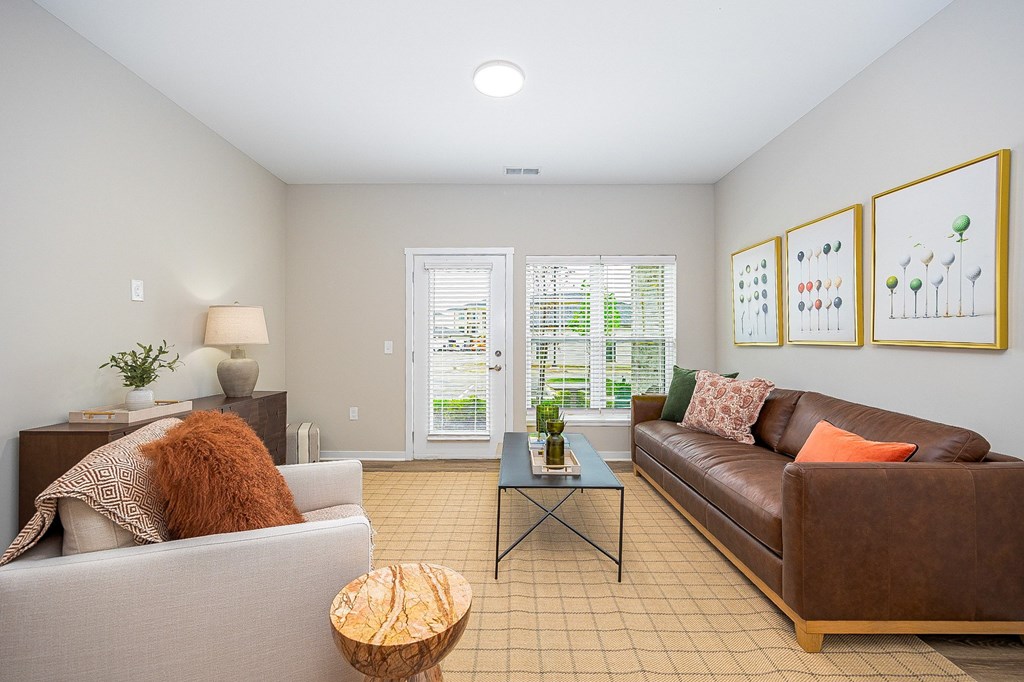 A living room with a brown couch, a white couch, and a coffee table.