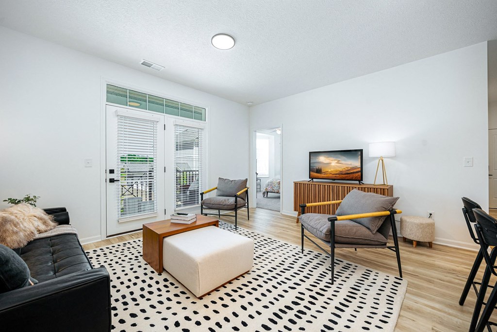 a living room with a couch and a chair and a television