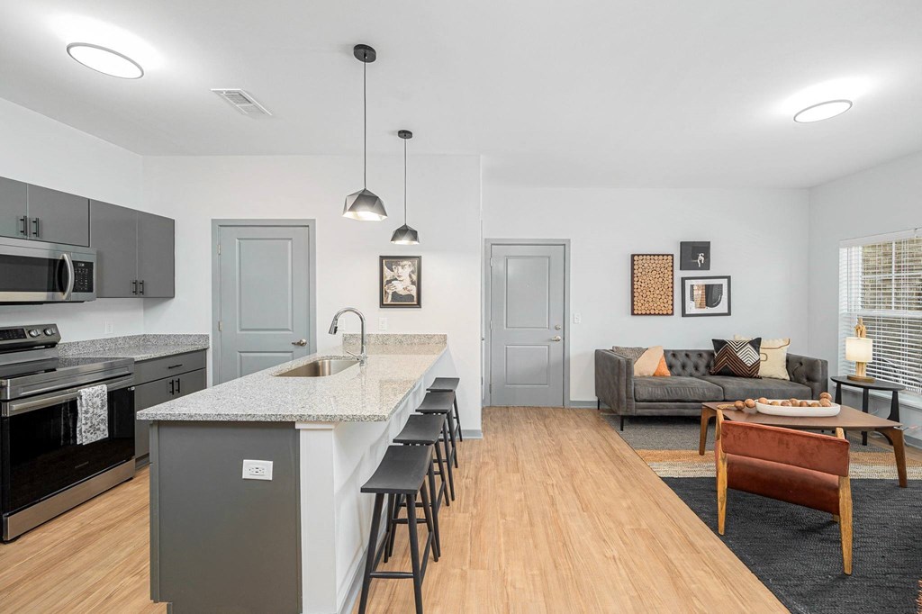a kitchen with a long island and a living room with a couch