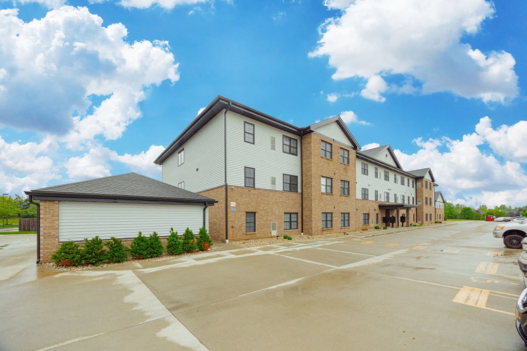 an empty parking lot in front of an apartment building