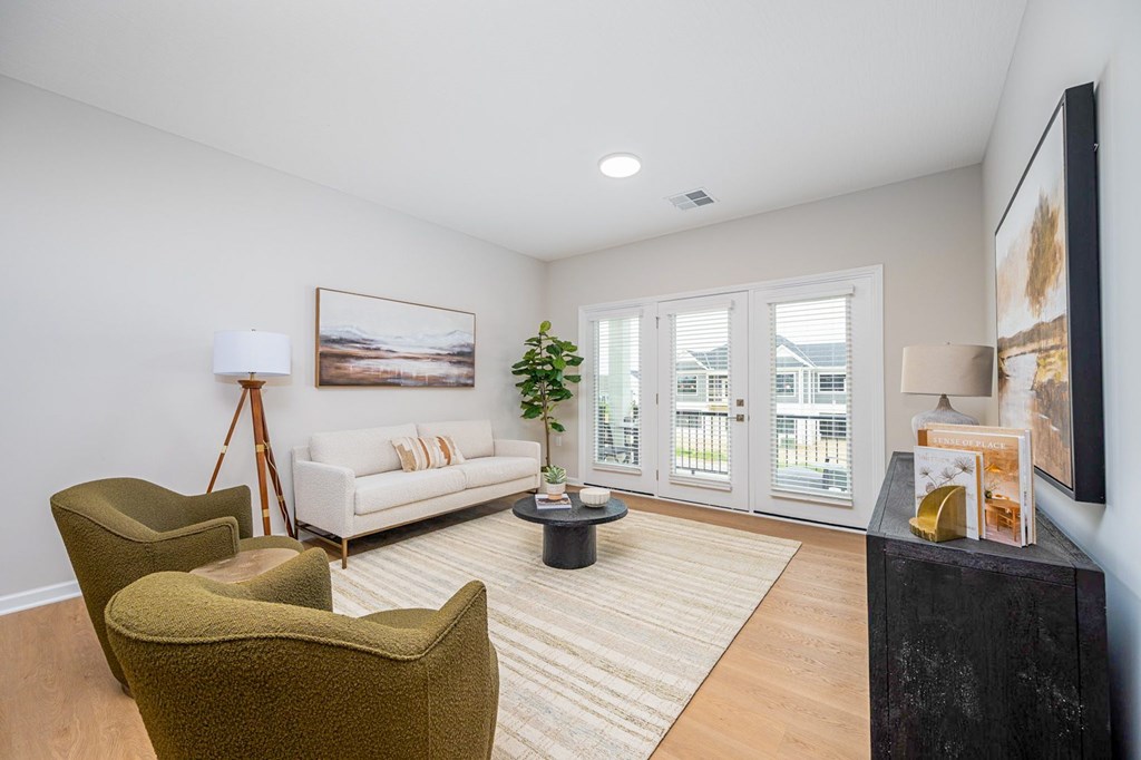 A living room with a white couch, a green armchair, and a coffee table.