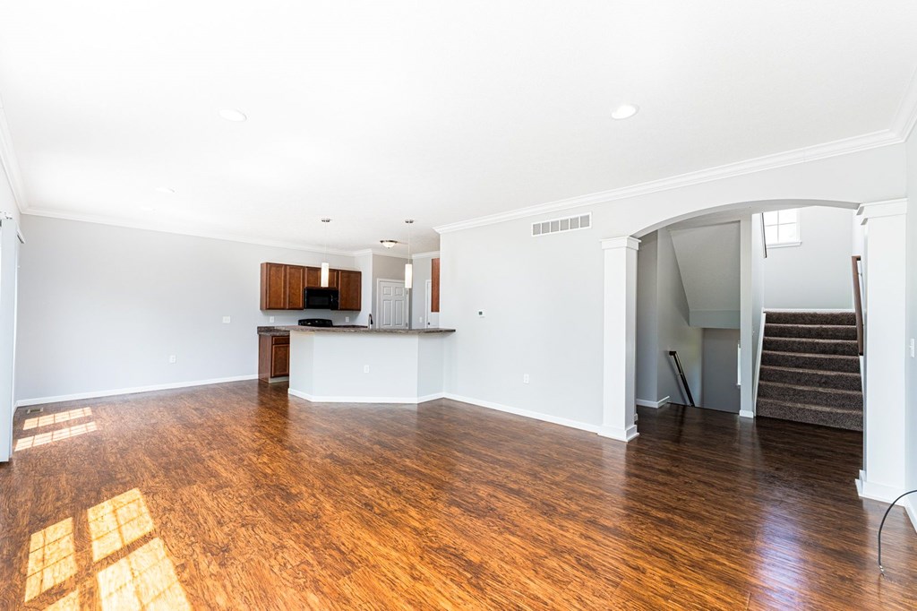A large empty room with wooden floors and white walls.