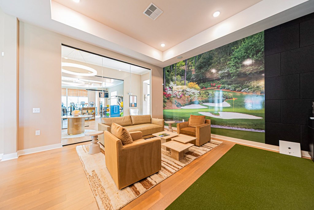 A living room with a couch and a green artificial grass area.