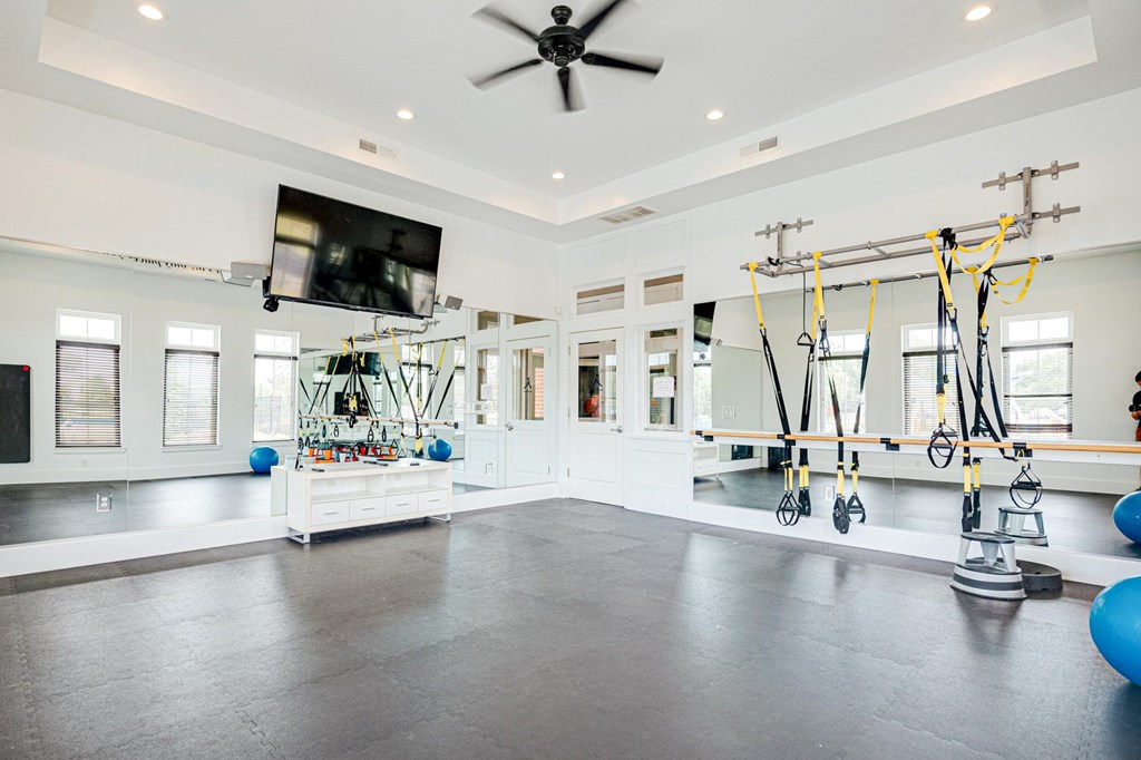 a home gym with weights and a tv on the wall