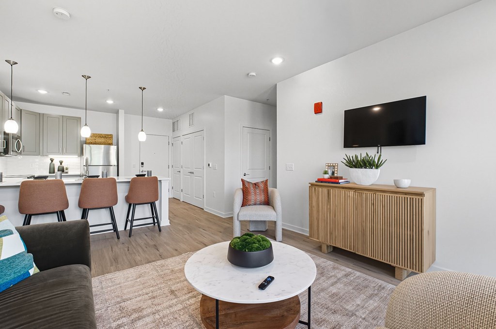 A living room with a white table and brown chairs.