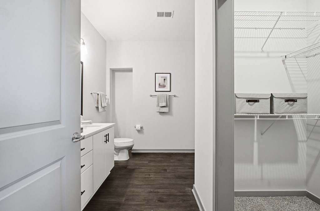 A bathroom with a toilet, sink, and mirror.