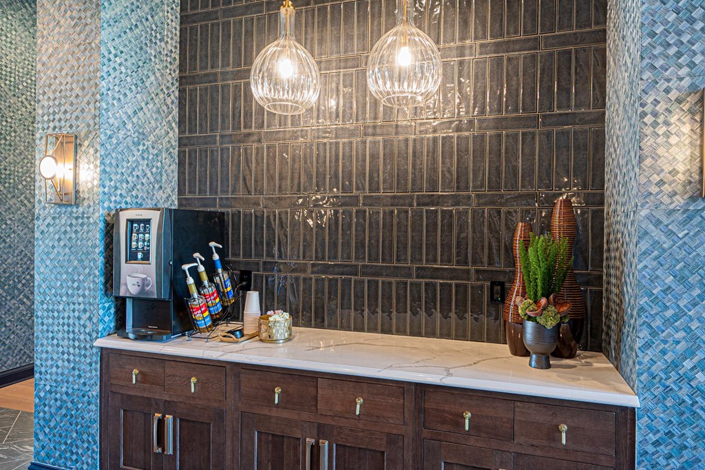 A kitchen counter with a coffee machine and a vase of flowers.