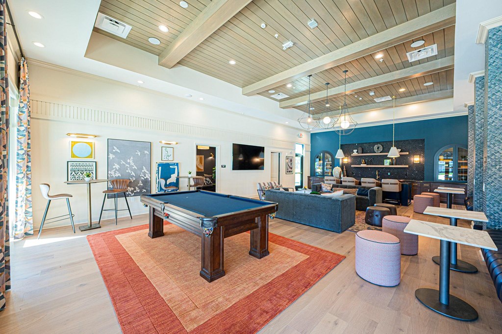 A billiard table is in the middle of a room with a blue wall.