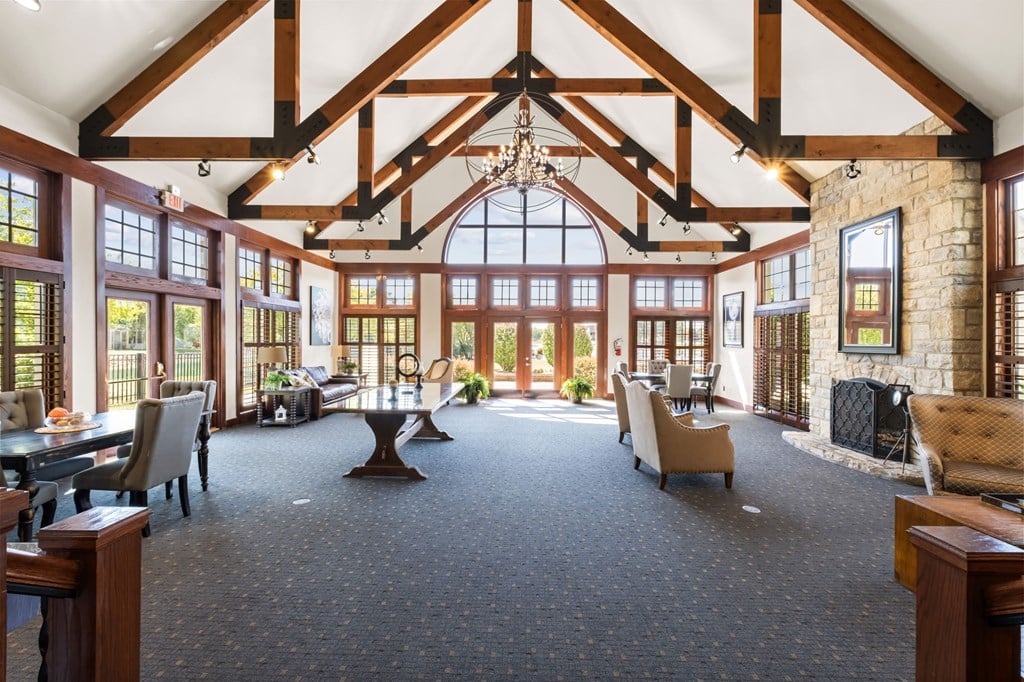 A large room with a high ceiling and a stone fireplace.