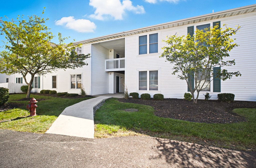 A white building with a red fire hydrant in front of it.