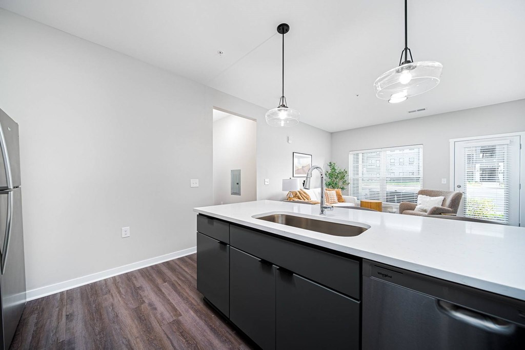 A kitchen with black cabinets and a white countertop.