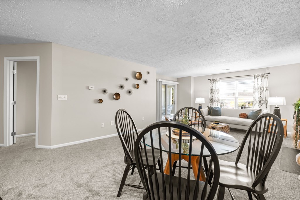 A dining room with a table set for four.