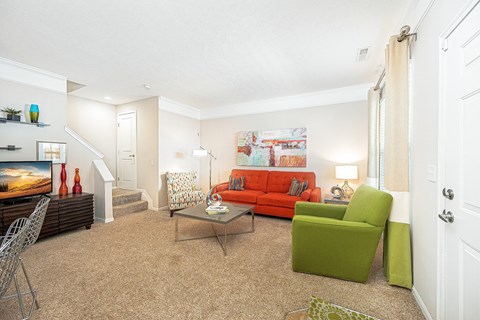 a living room with a red couch and a green chair