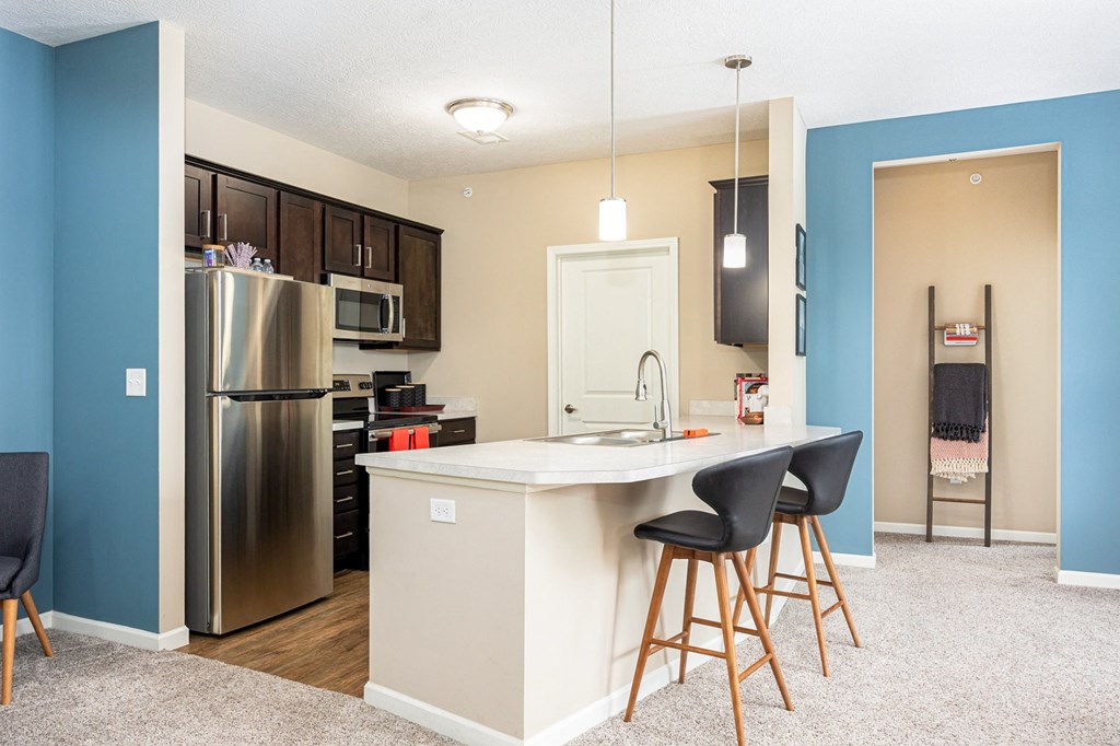 a kitchen with a island and a stainless steel refrigerator