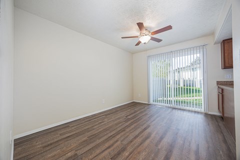 A room with a ceiling fan and sliding glass doors.
