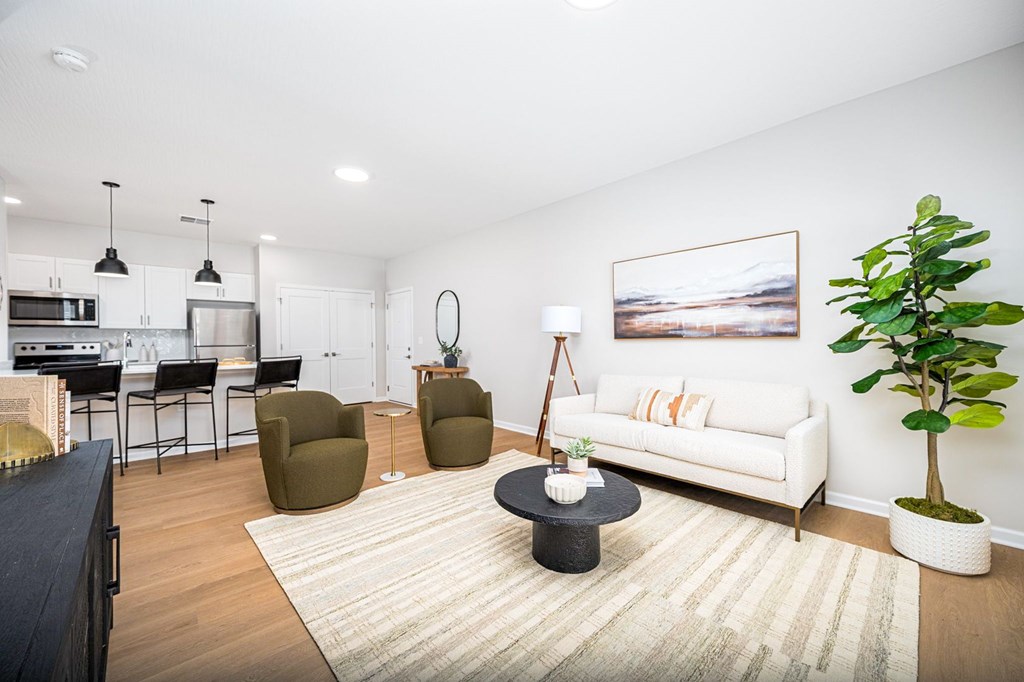 A living room with a white couch and a painting on the wall.