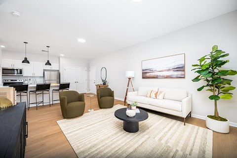 A living room with a white couch and a painting on the wall.