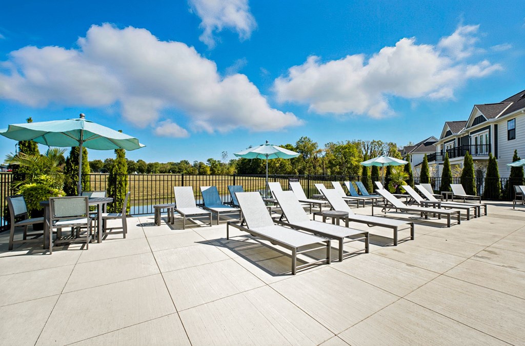 A sunny day at the outdoor pool area with lounge chairs and umbrellas.