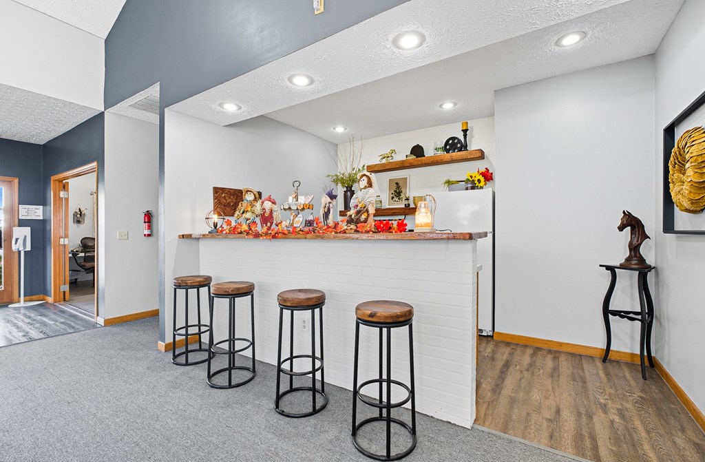 A bar area with four stools in front of it.