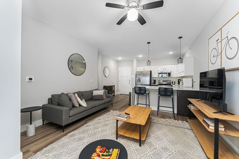 A living room with a grey couch and a wooden coffee table.