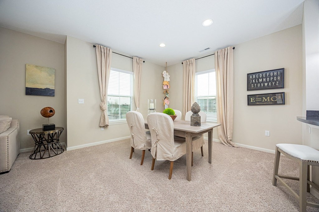 A dining room with a table and chairs.