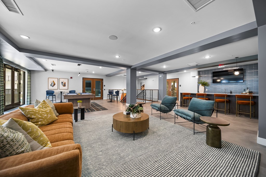 A modern living room with a striped carpet and a variety of furniture.