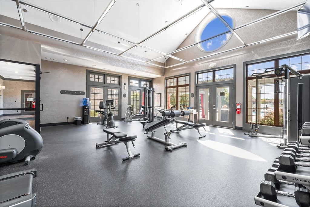 A gym with a variety of equipment including treadmills, weights, and exercise machines.