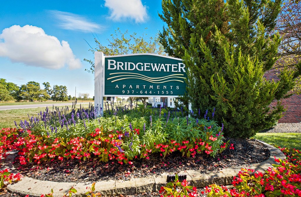 A sign for Bridgewater Apartments is surrounded by flowers.