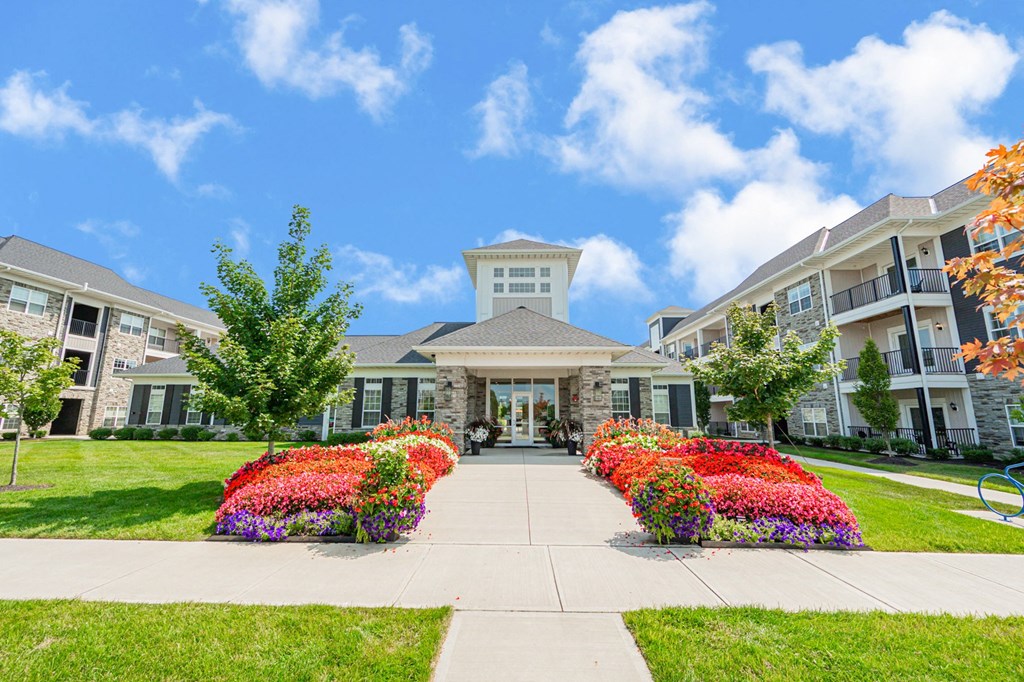 a building with a sidewalk and colorful flowers in front of it