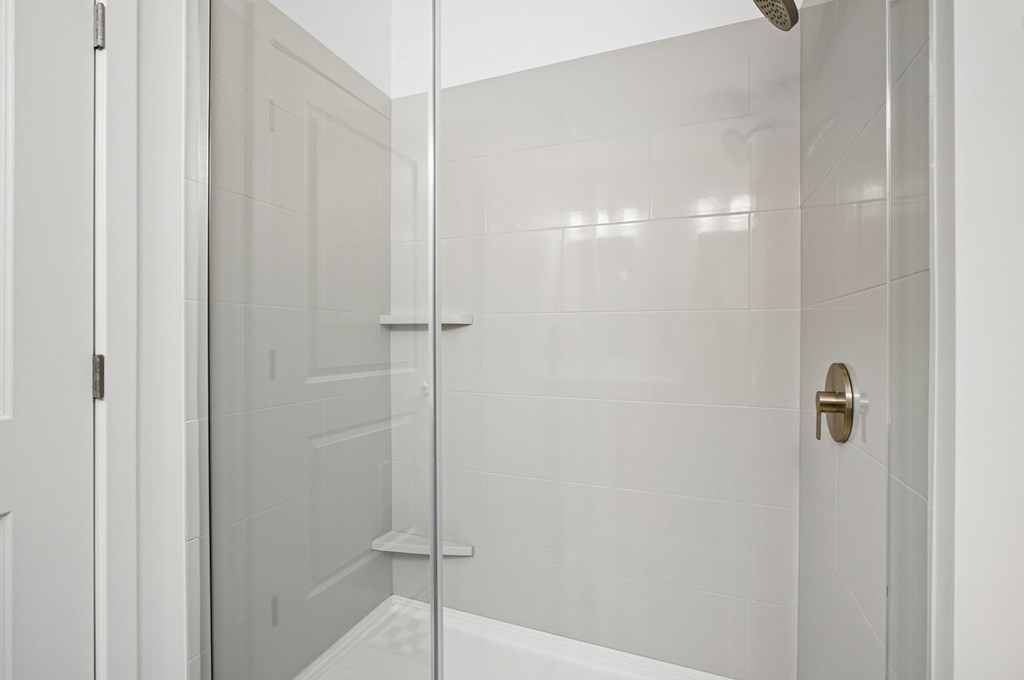 A white bathroom with a glass shower door.