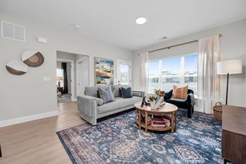 A living room with a grey couch and a round coffee table.