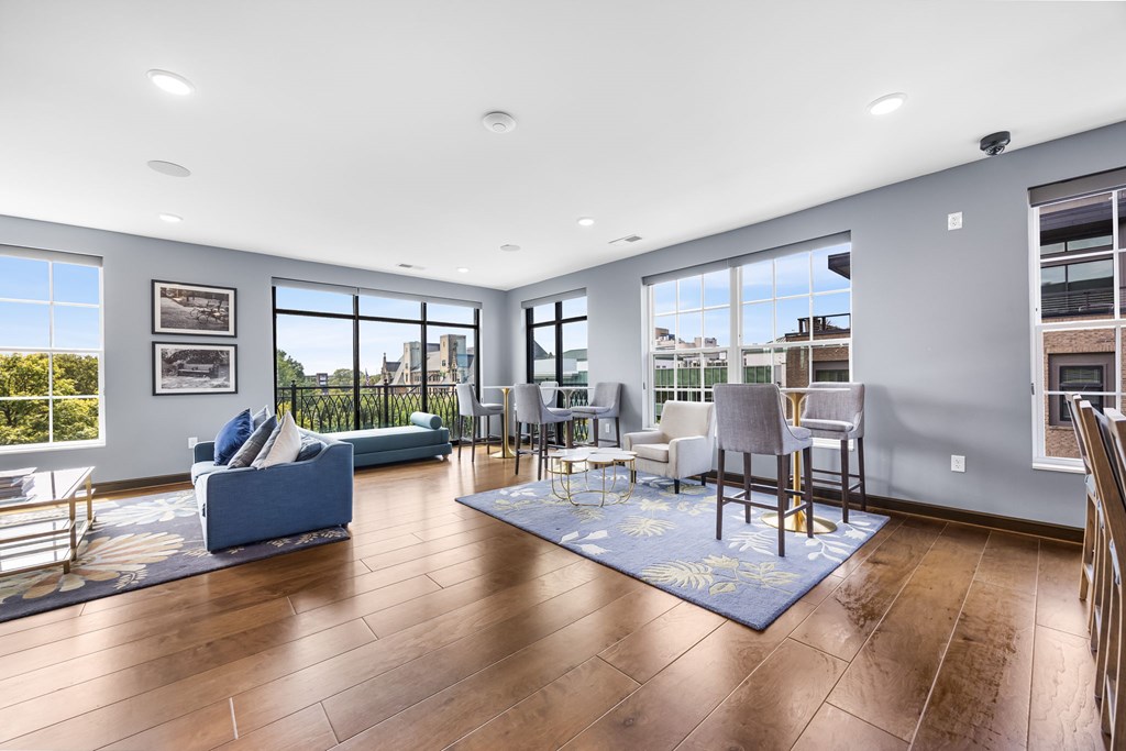 A living room with a blue couch and a rug.