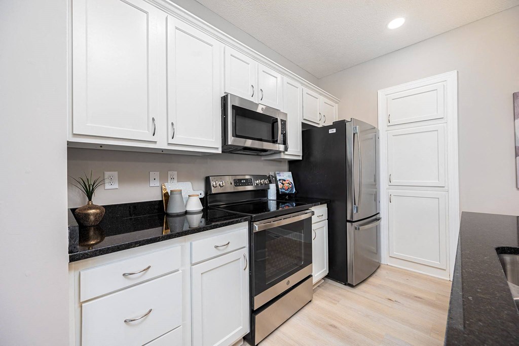 a kitchen with white cabinets and stainless steel appliances