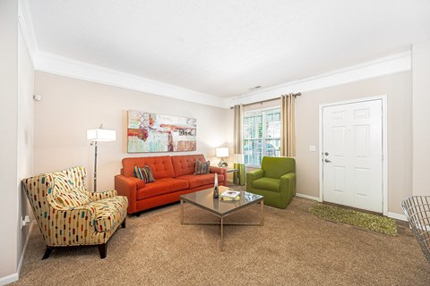 a living room with a couch and chairs and a table