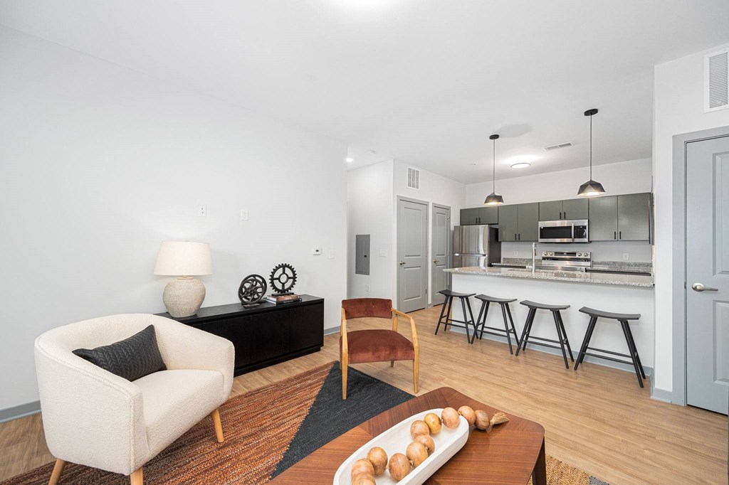 a living room with a couch and a chair and a kitchen