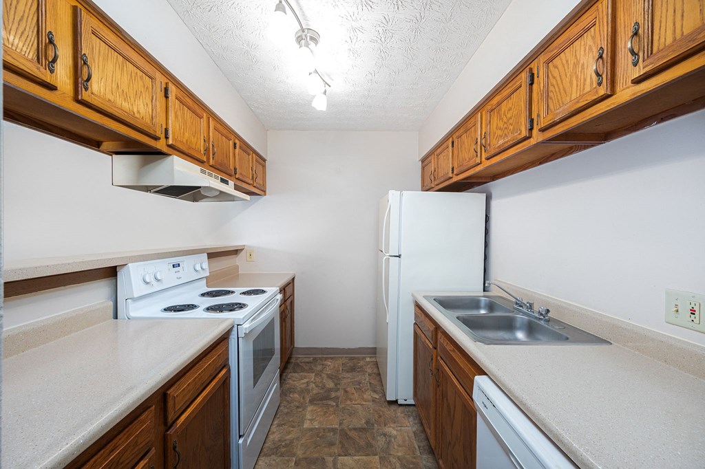 a kitchen with white appliances and wooden cabinets