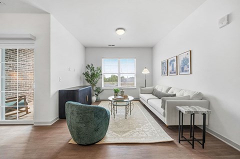 A living room with a green chair and a white couch.