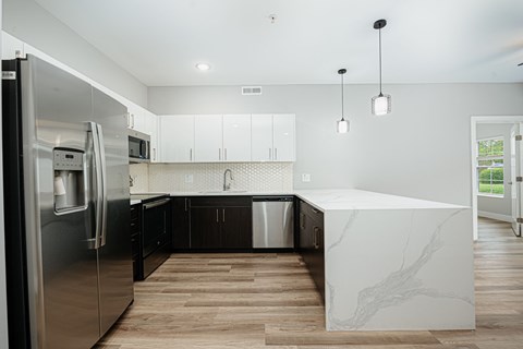 a kitchen with a marble island and stainless steel appliances