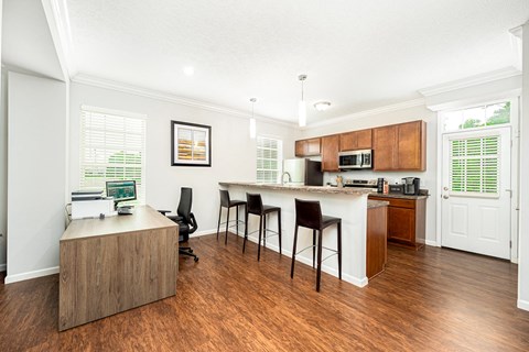 a living room with a kitchen and a bar with chairs